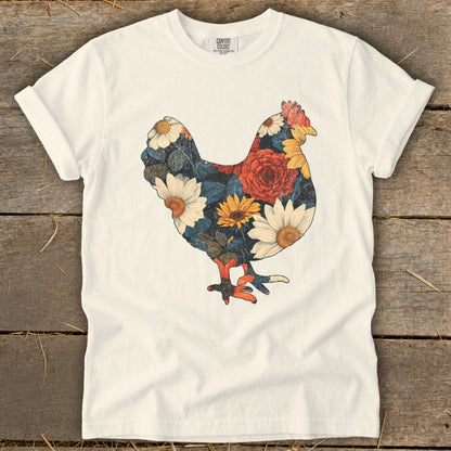 White t-shirt with a floral chicken graphic in shades of red, yellow, and blue.