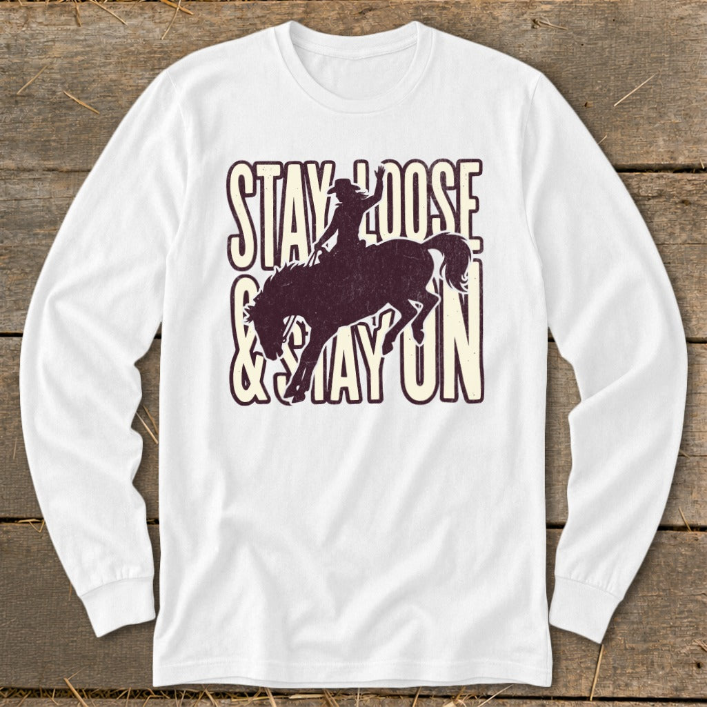 White long sleeve shirt with "STAY LOOSE & STAY ON" text and bronc rider graphic.