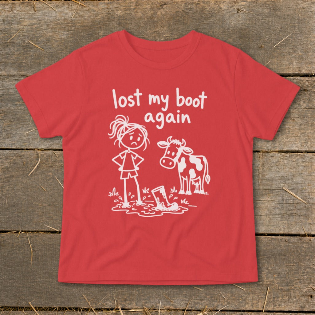 A red t-shirt printed with a graphic of a sad girl and a cow looking at a muddy boot, with the text "lost my boot again."