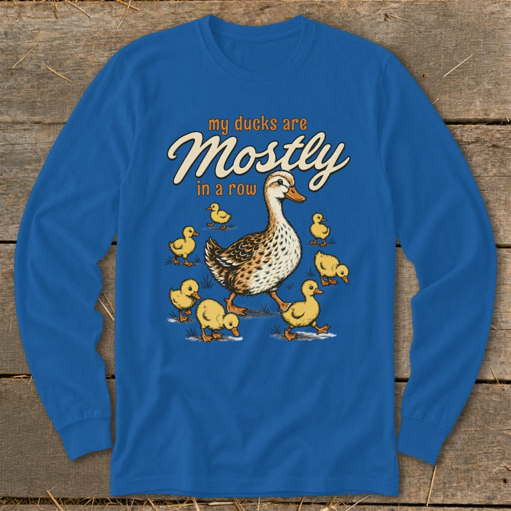 A duck and ducklings walk on grass with text "my ducks are Mostly in a row".