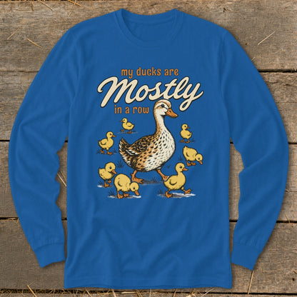 A duck and ducklings walk on grass with text "my ducks are Mostly in a row".