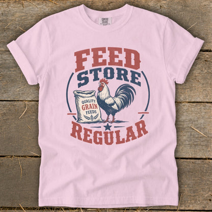 Pink t-shirt graphic with rooster and "Feed Store Regular" text.