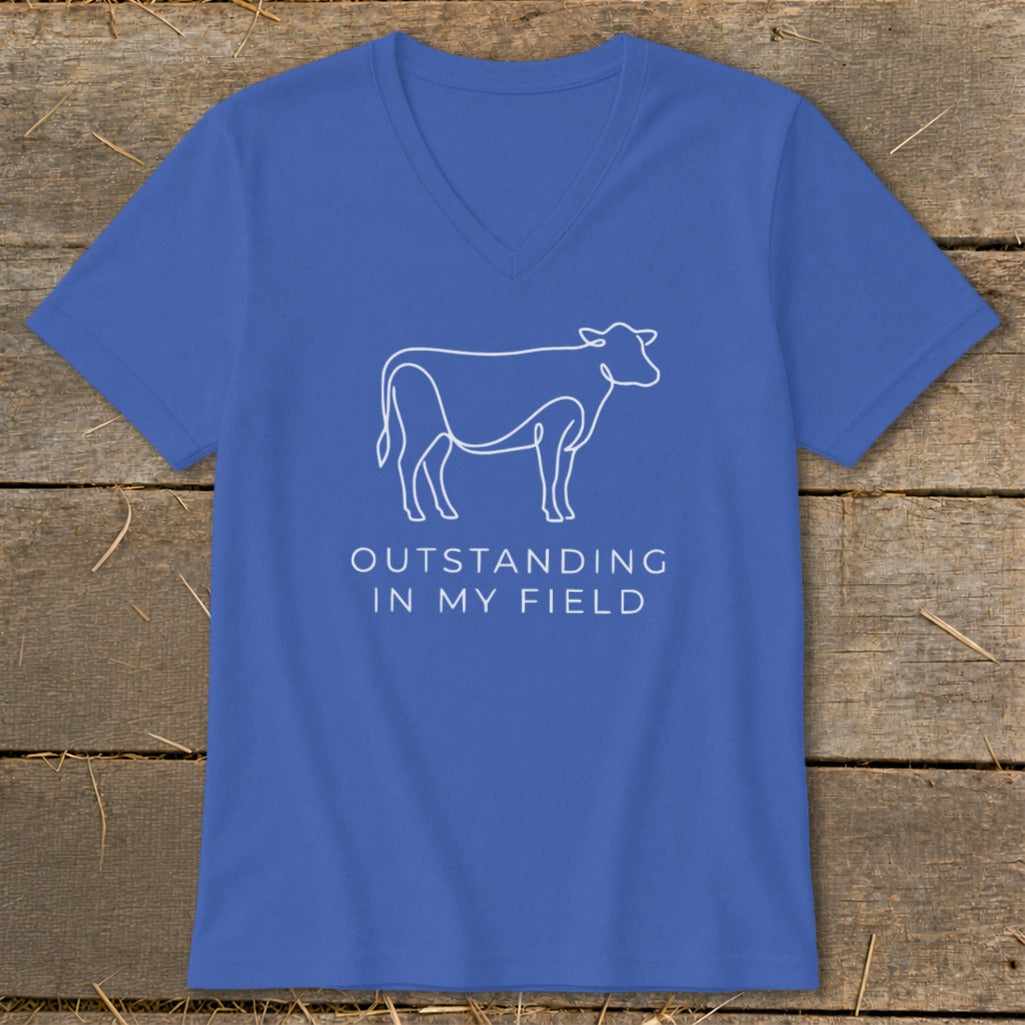 Blue v-neck t-shirt with white line drawing of a cow and text "OUTSTANDING IN MY FIELD".