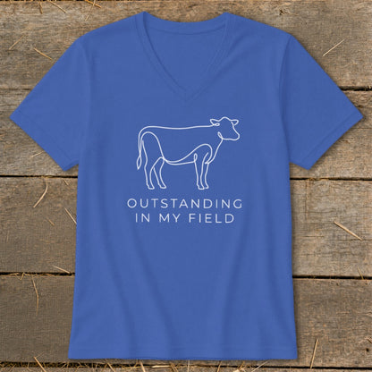 Blue v-neck t-shirt with white line drawing of a cow and text "OUTSTANDING IN MY FIELD".