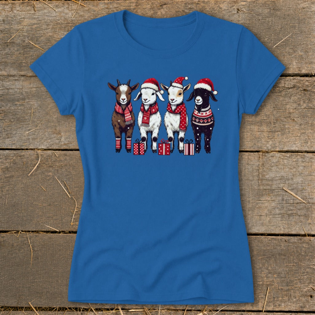Blue t-shirt with four cartoon goats wearing Santa hats and scarves, standing near gifts.