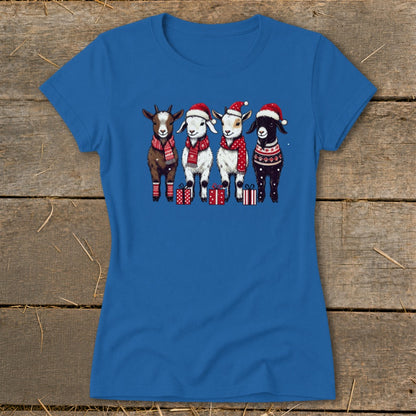 Blue t-shirt with four cartoon goats wearing Santa hats and scarves, standing near gifts.