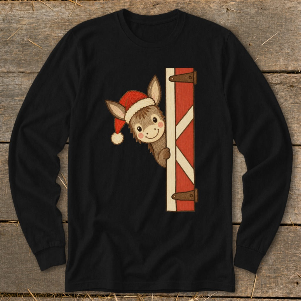 Cute donkey wearing a Santa hat peeking from behind a red barn door.