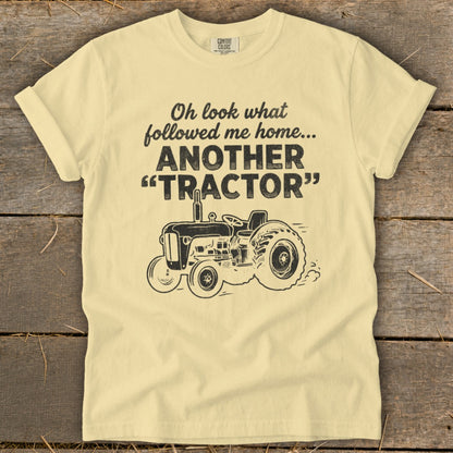 Light yellow t-shirt with "Oh look what followed me home... ANOTHER 'TRACTOR'" and tractor graphic.