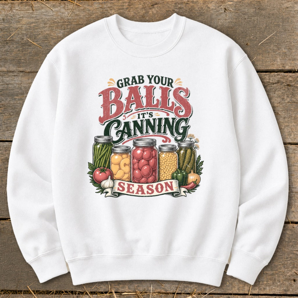 White sweatshirt with "Grab Your Balls It's Canning Season" text and jars of preserved food.
