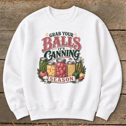 White sweatshirt with "Grab Your Balls It's Canning Season" text and jars of preserved food.