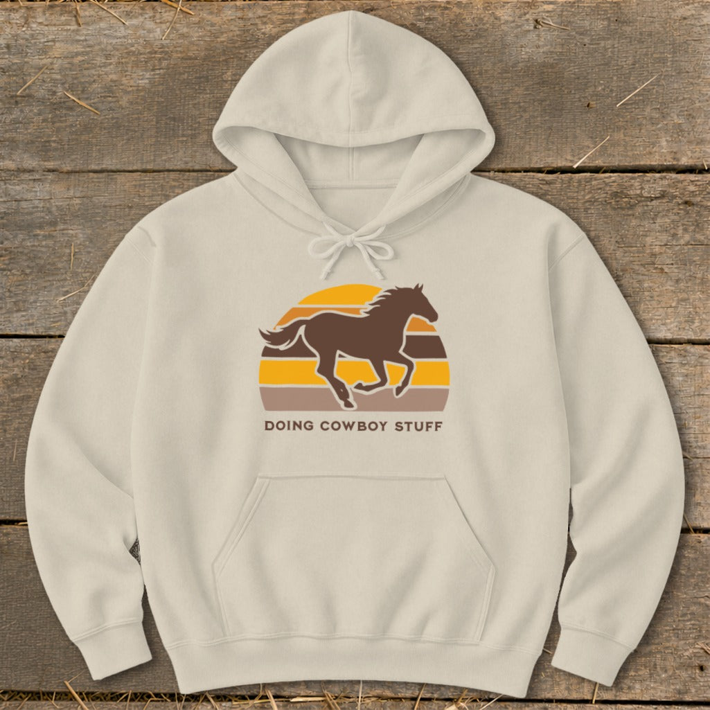 Light beige hoodie with brown horse silhouette and "DOING COWBOY STUFF" text.