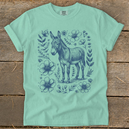 Mint green t-shirt with blue donkey and floral sketch graphic.