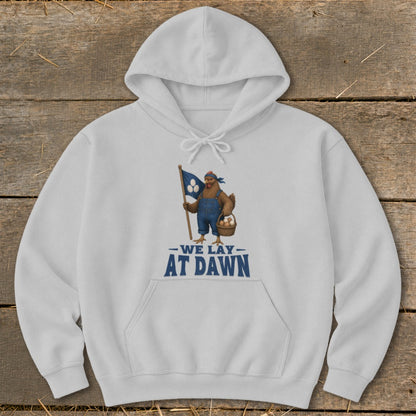 White hoodie with a chicken holding a flag and basket, reads "We Lay At Dawn".