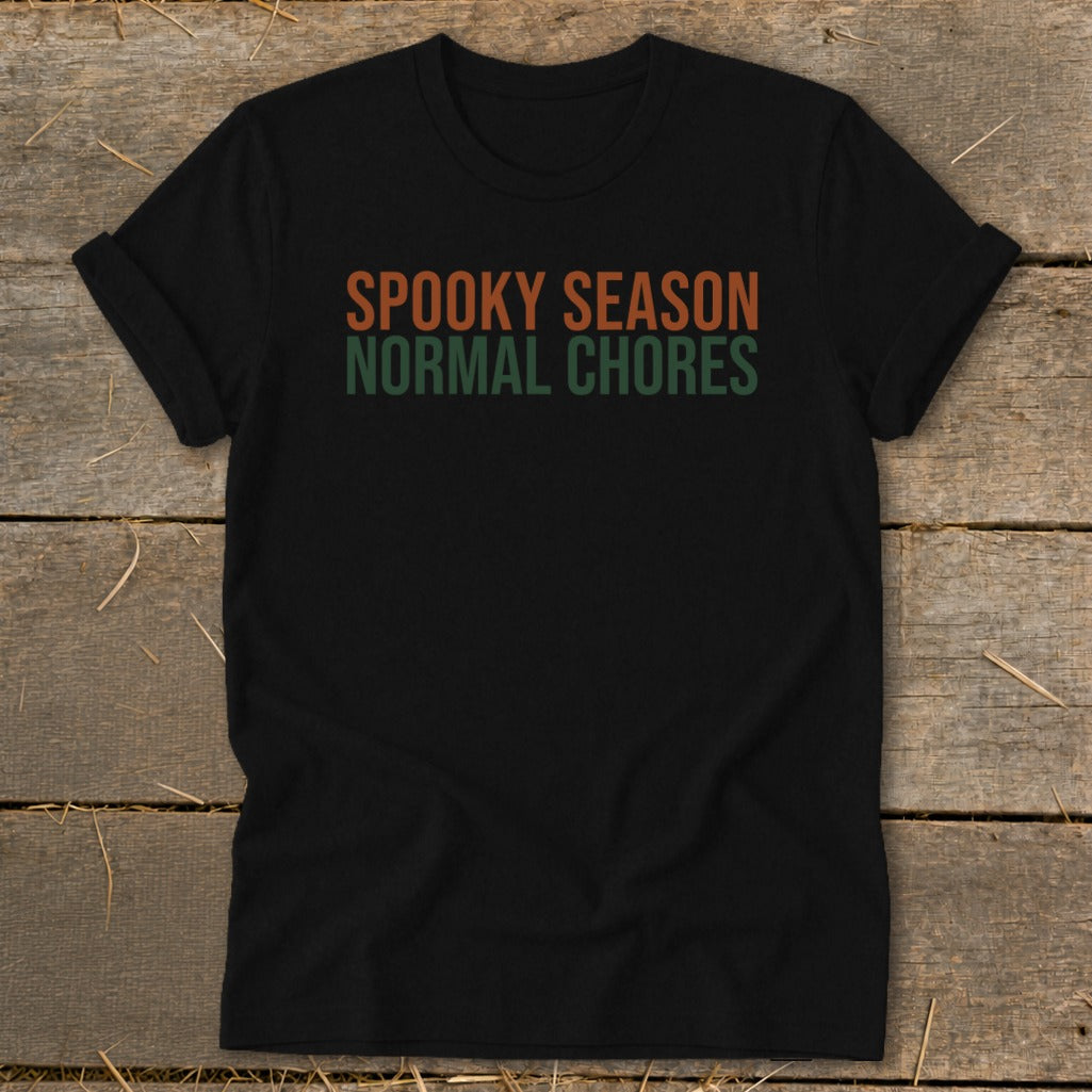 Black t-shirt with orange and green text: Spooky Season, Normal Chores.