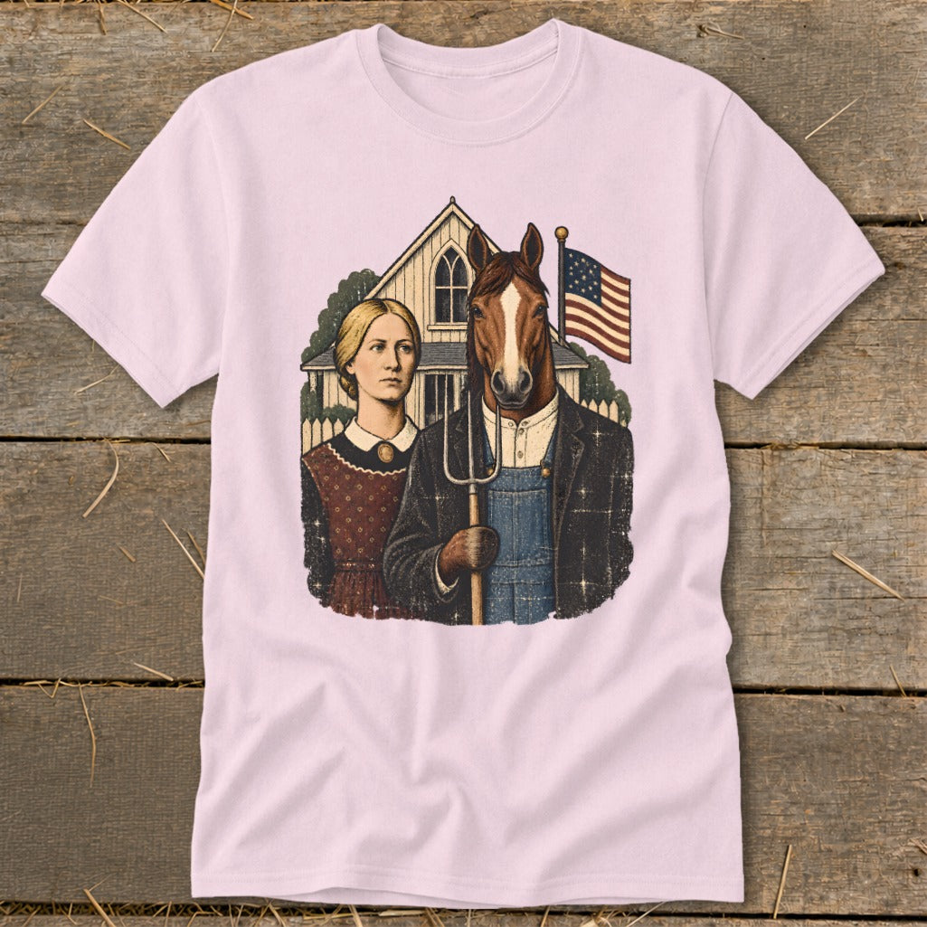 A light pink t-shirt featuring a humorous American Gothic parody graphic with a horse holding a pitchfork.