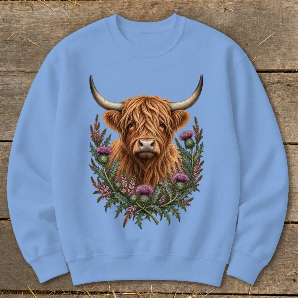 Highland cow with thistle wreath graphic on light blue sweatshirt