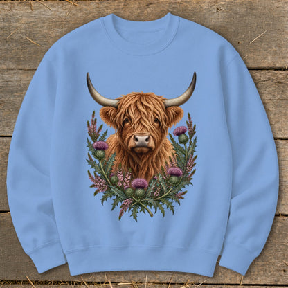 Highland cow with thistle wreath graphic on light blue sweatshirt