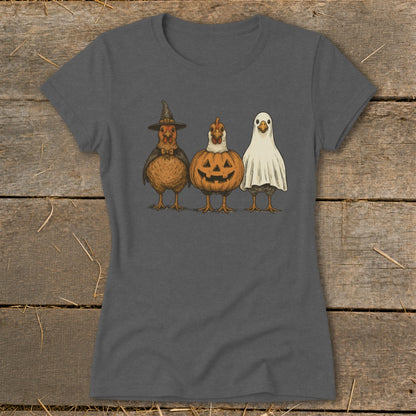 Three chickens dressed in Halloween costumes: witch, pumpkin, and ghost.