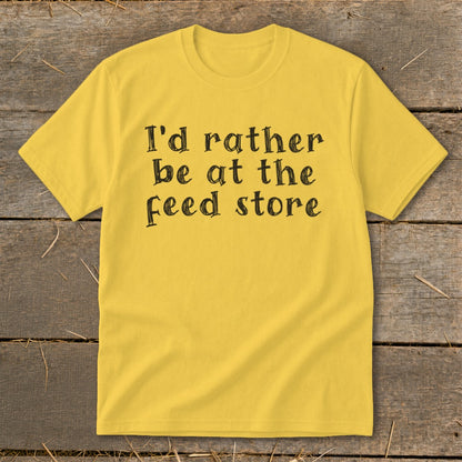 Yellow t-shirt with black text that reads "I'd rather be at the feed store".
