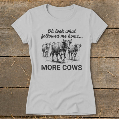 Light grey t-shirt with "Oh look what followed me home... MORE COWS" and cow illustration.