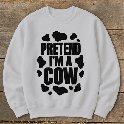 White crewneck sweatshirt with "Pretend I'm a Cow" text and black cow spots.
