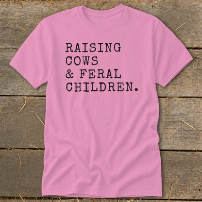 Pink t-shirt with black text that reads "RAISING COWS & FERAL CHILDREN."