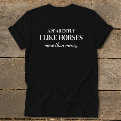 Black t-shirt with white text "Apparently I like horses more than money."