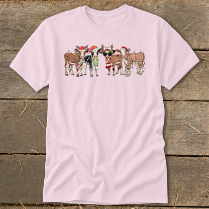 Five cartoon cows wearing Santa hats and Christmas lights, with one cow wearing sunglasses and a scarf.