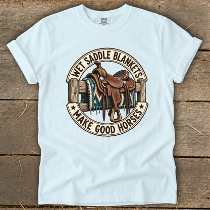 Light blue t-shirt with saddle, blanket, and text "Wet Saddle Blankets Make Good Horses."