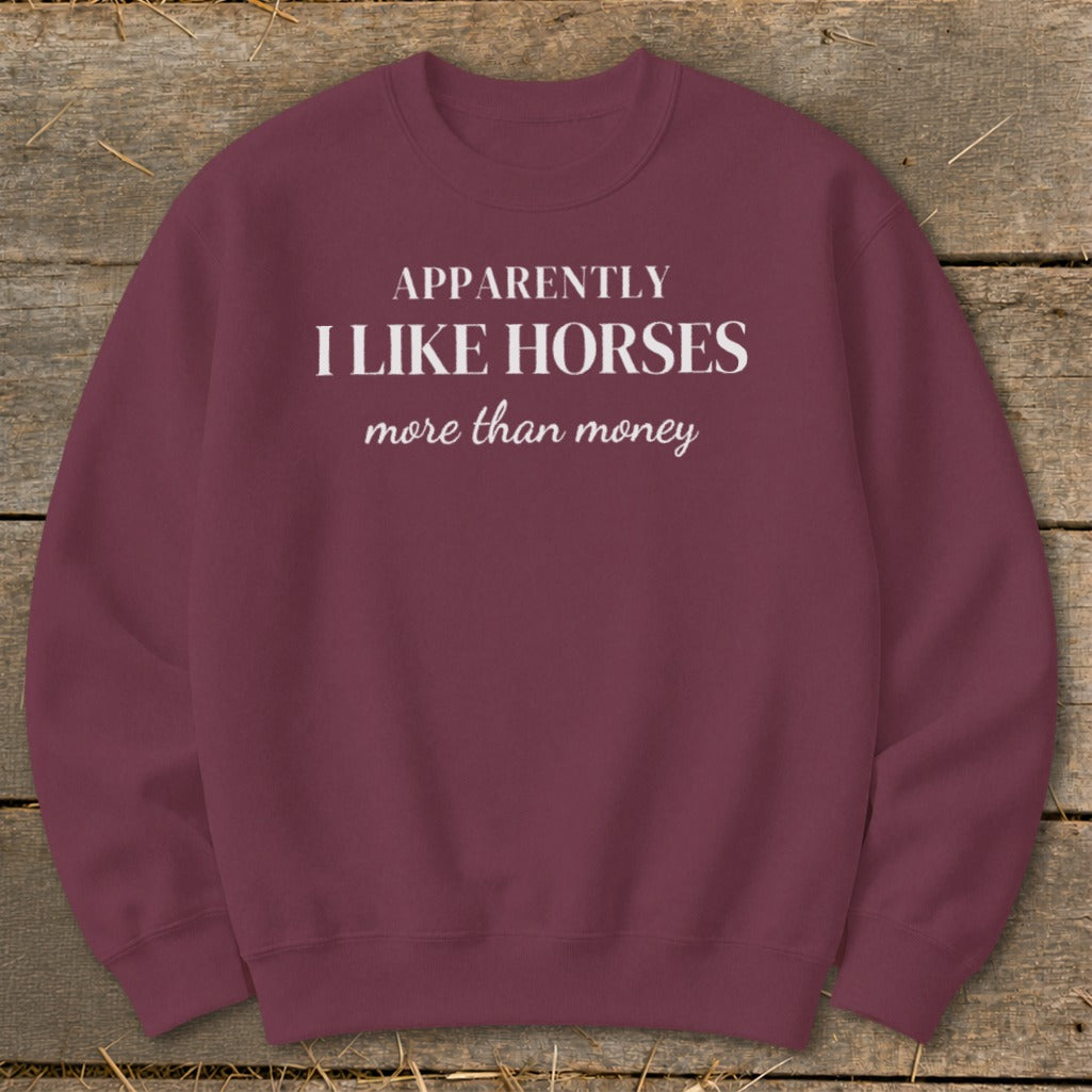 Maroon sweatshirt with white text "APPARENTLY I LIKE HORSES more than money".