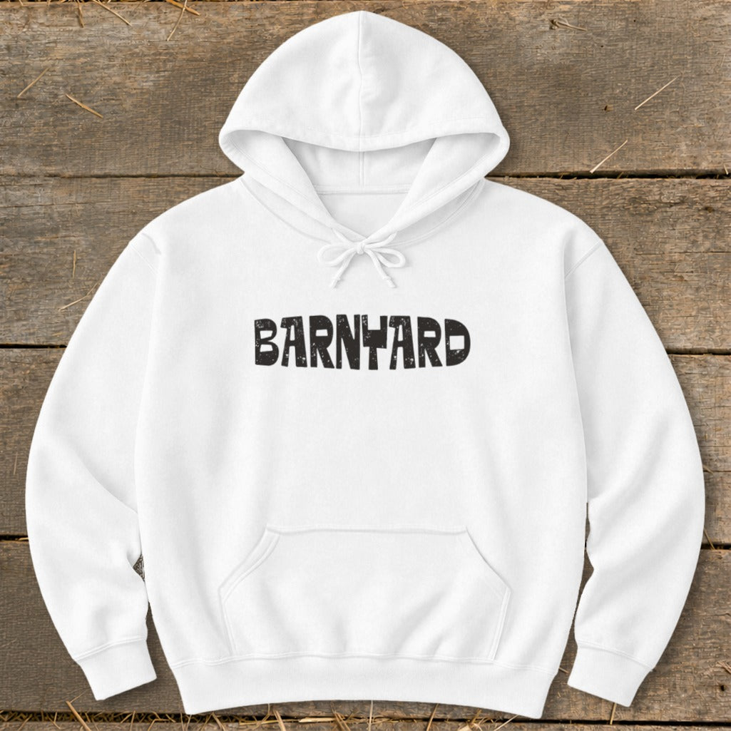 A white hooded sweatshirt featuring the text BARNYARD centered across the chest, laid flat on a wooden surface.