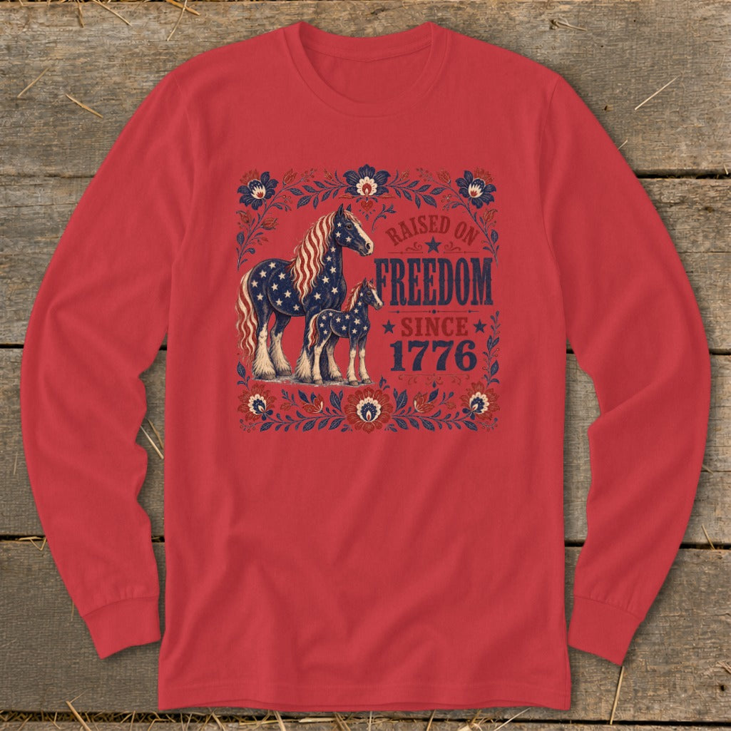 Red long-sleeve shirt with patriotic horses and floral design, "Raised on Freedom Since 1776."