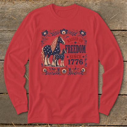 Red long-sleeve shirt with patriotic horses and floral design, "Raised on Freedom Since 1776."