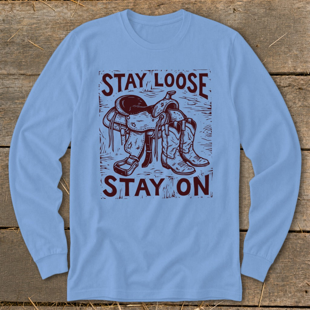 Blue long sleeve shirt with maroon graphic of a saddle and cowboy boots with text.