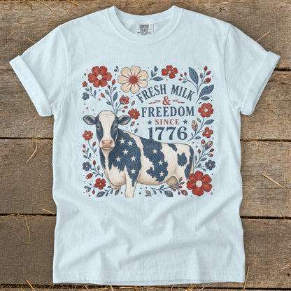 White t-shirt with patriotic cow and floral design, "Fresh Milk & Freedom Since 1776".