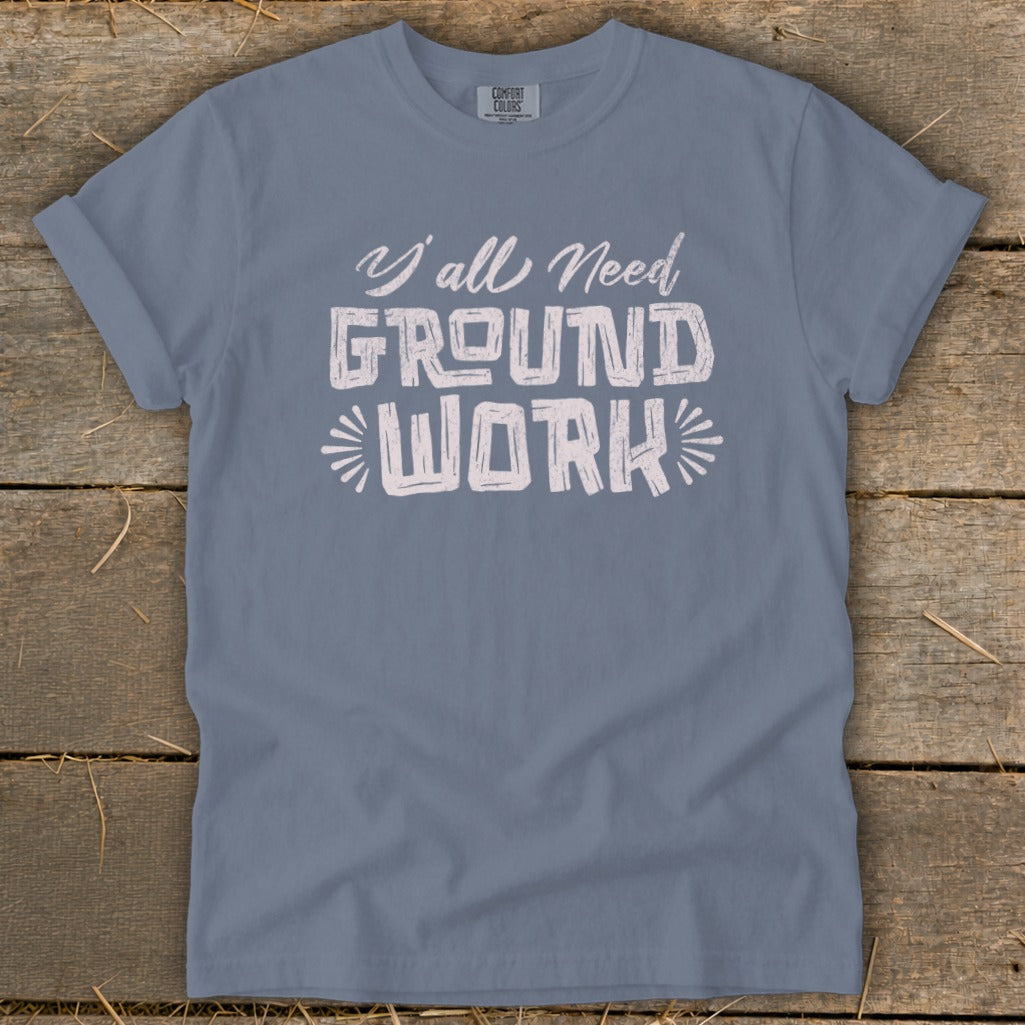 Blue t-shirt with white text "Y'all Need GROUND WORK" centered.