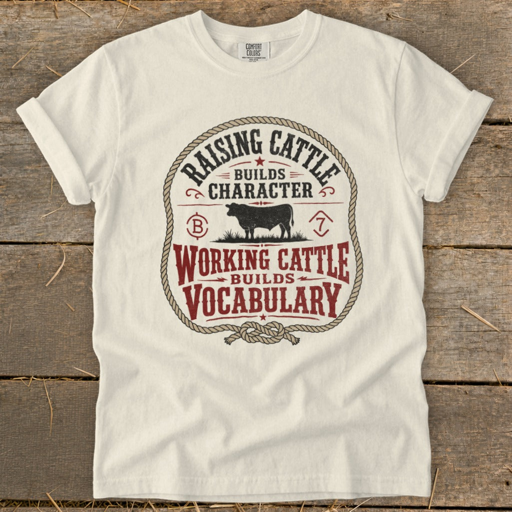 Cream t-shirt with text "Raising cattle builds character. Working cattle builds vocabulary" and a bull.