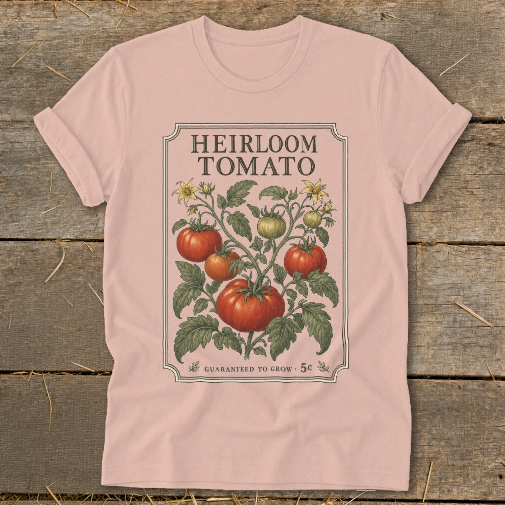 Pink t-shirt with "Heirloom Tomato" design featuring a vine with ripe and unripe tomatoes and yellow flowers.