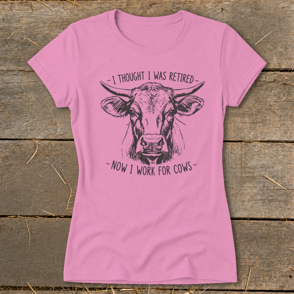 Pink t-shirt with black sketch of a cow and text "I thought I was retired - Now I work for cows."