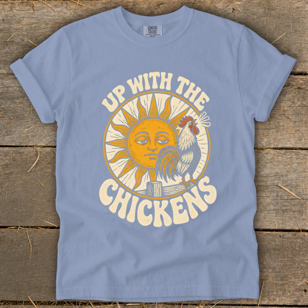 Light blue t-shirt featuring a retro graphic of a sun, rooster, and the text Up With The Chickens.