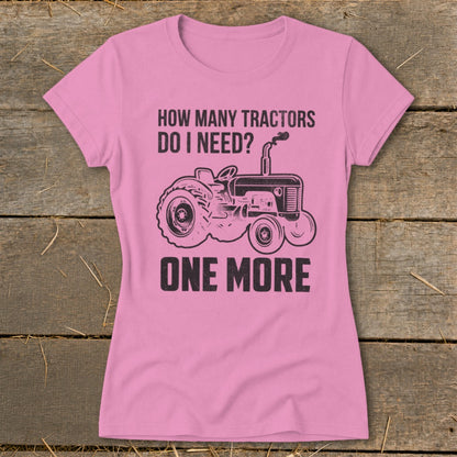 Pink t-shirt with black graphic of a tractor and text "How Many Tractors Do I Need? One More".