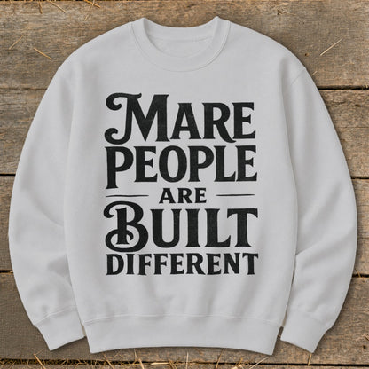 White sweatshirt with "Mare People Are Built Different" text in black.