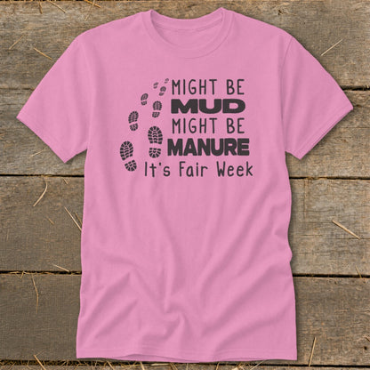 Pink t-shirt with black text and footprints that reads "Might Be Mud, Might Be Manure, It's Fair Week".
