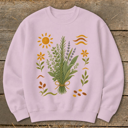 Pink sweatshirt with a bouquet of herbs and wildflowers, sun, and seeds.