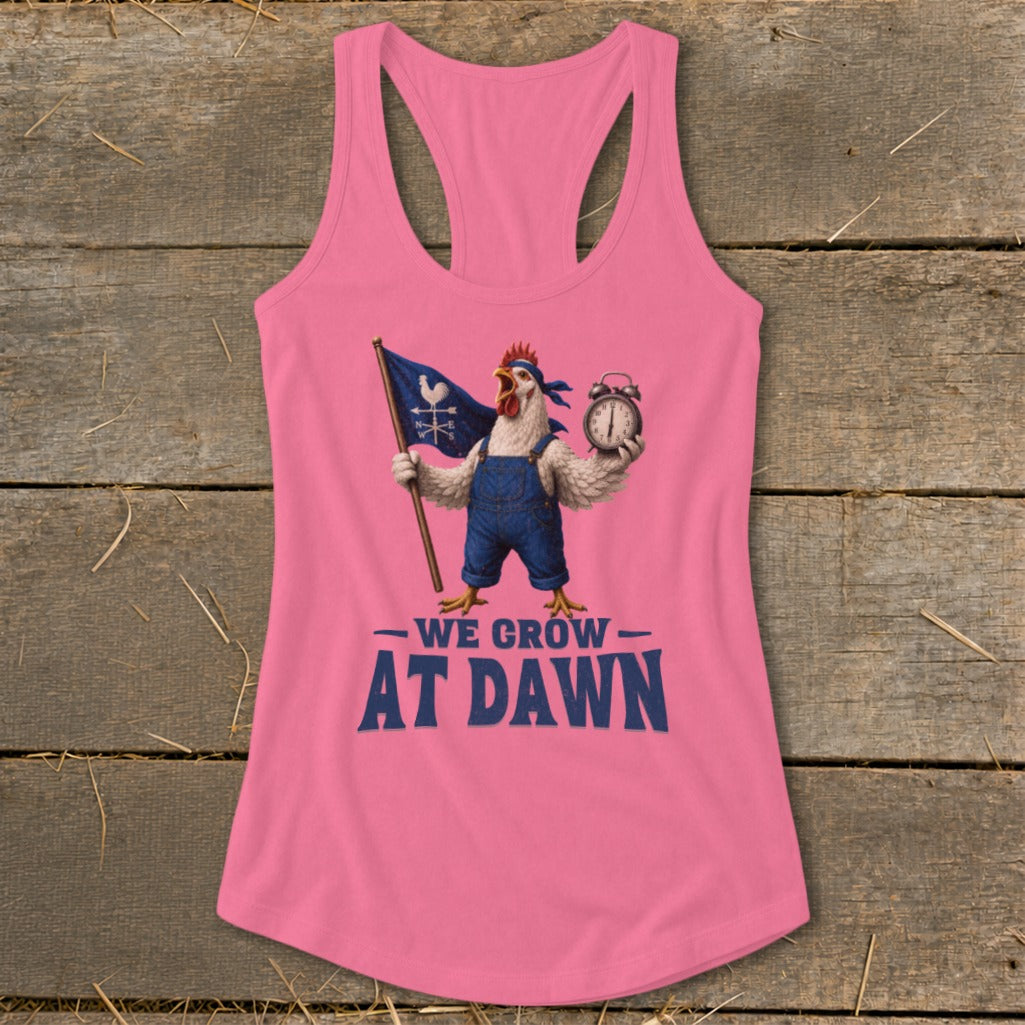 Pink tank top with a rooster holding a flag and alarm clock, text reads "We Grow At Dawn".