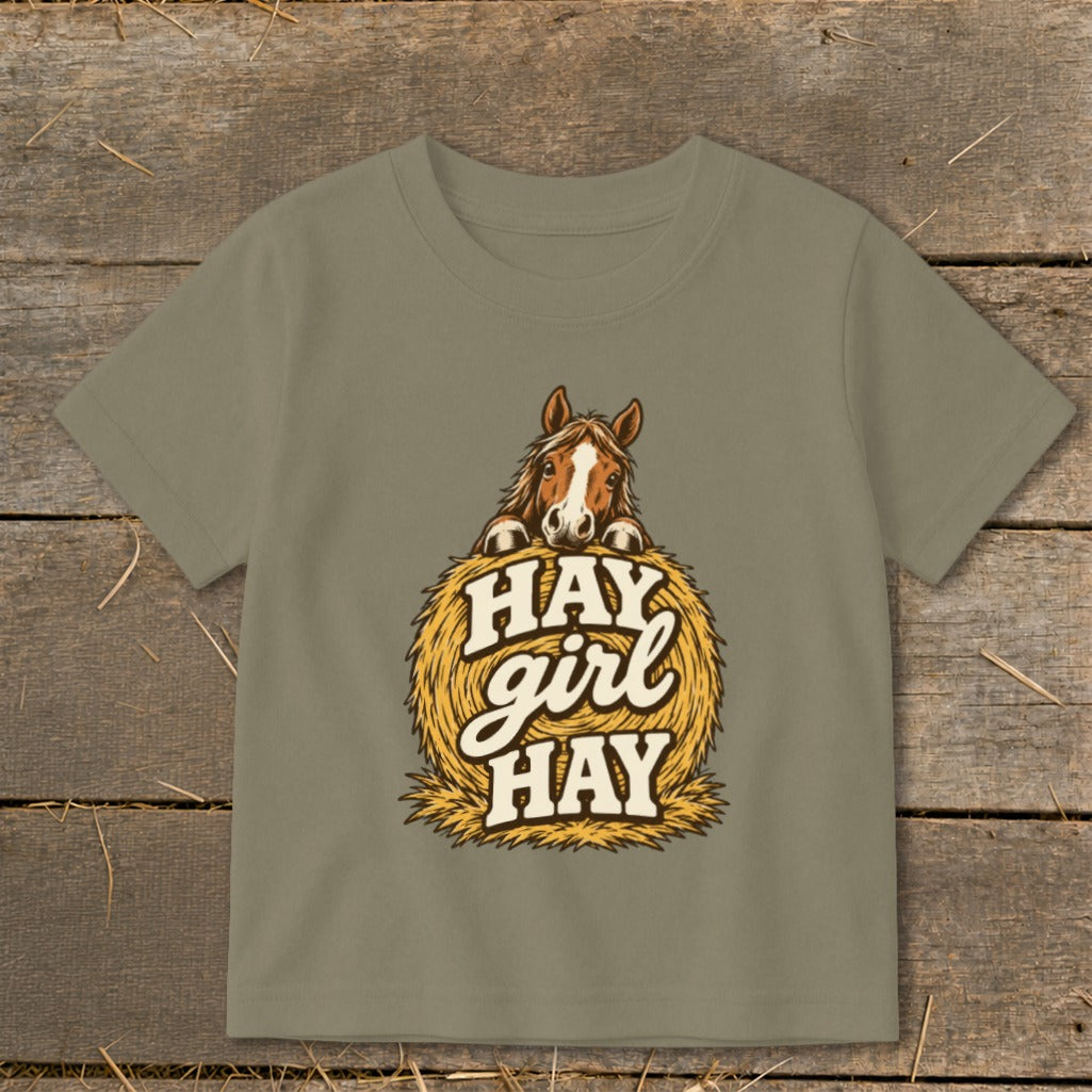 Brown horse peeking over a bale of hay with "Hay girl HAY" text.
