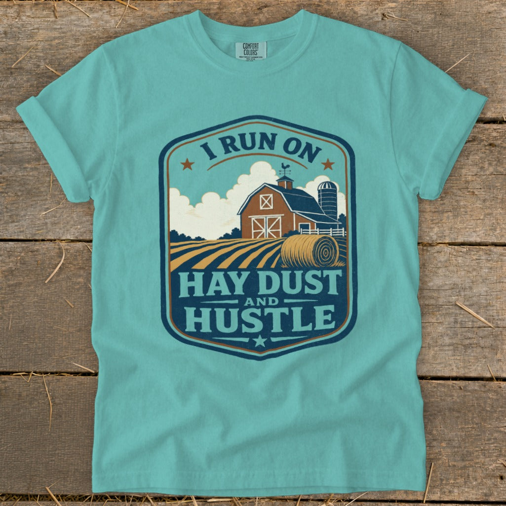 Teal t-shirt with "I run on hay dust and hustle" farm graphic.