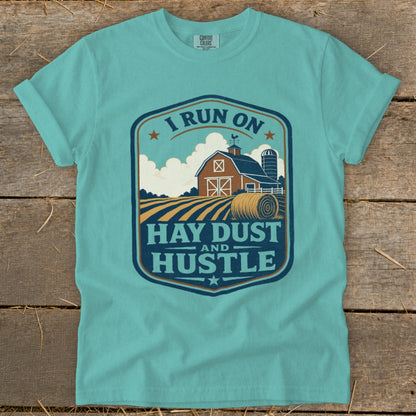Teal t-shirt with "I run on hay dust and hustle" farm graphic.