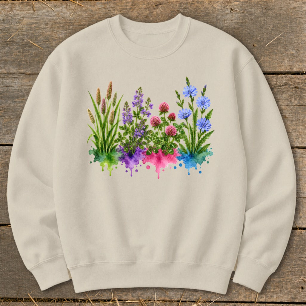 Beige crewneck sweatshirt featuring a watercolor graphic of four distinct wildflower clusters above colorful paint splatters.