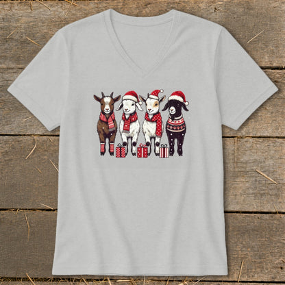 Four goats wearing Santa hats and scarves stand with Christmas gifts.